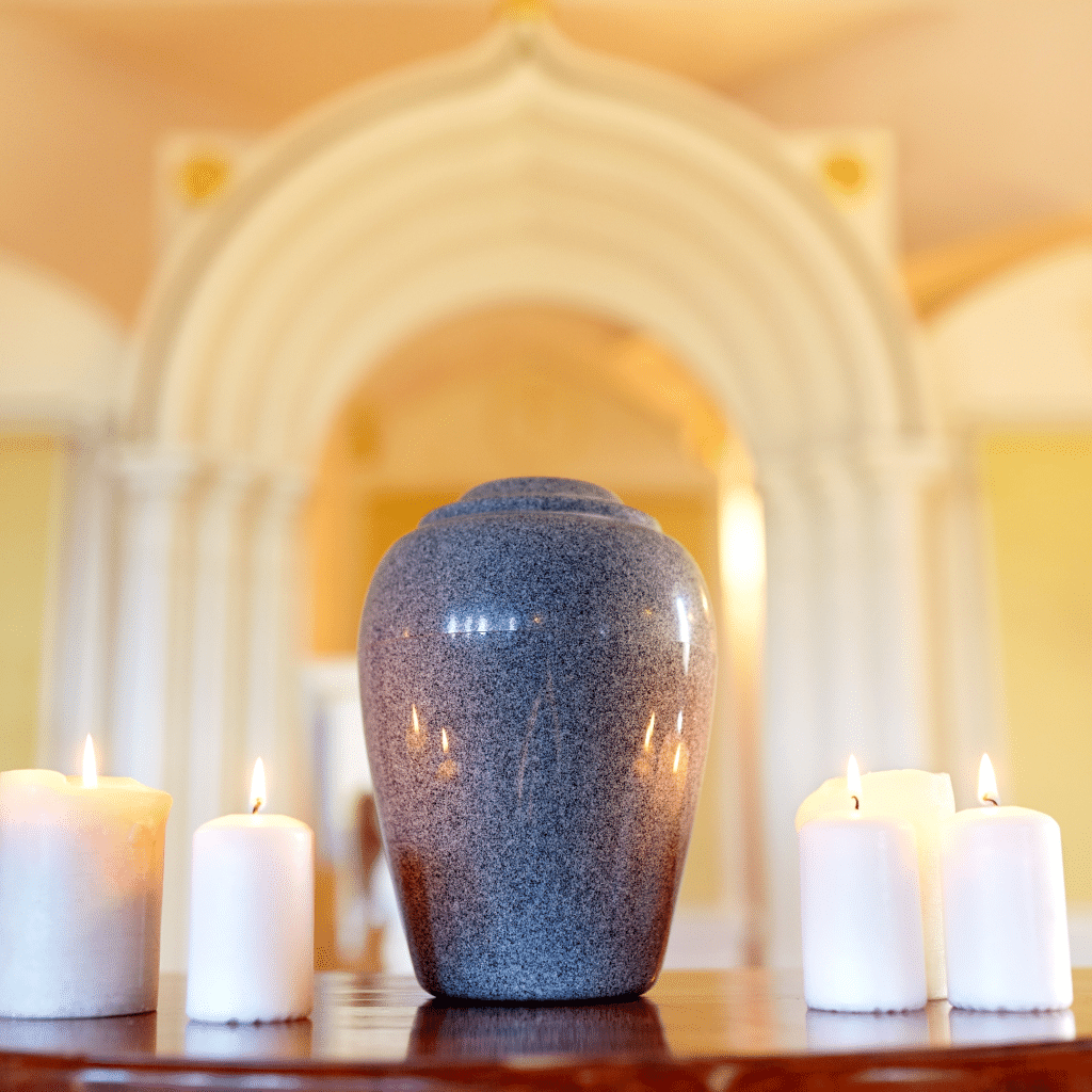 Image of a gray urn surrounded by candles, A Plus Cremation is a provider of urns for loved ones remains.