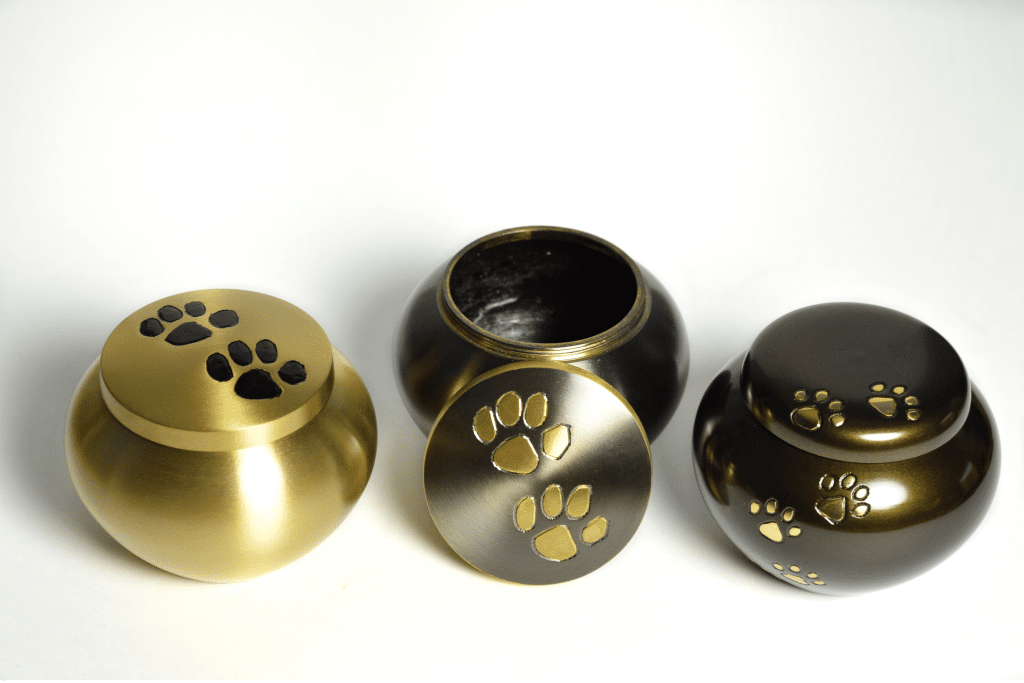 Image of 3 pet urns with 1 lid open
